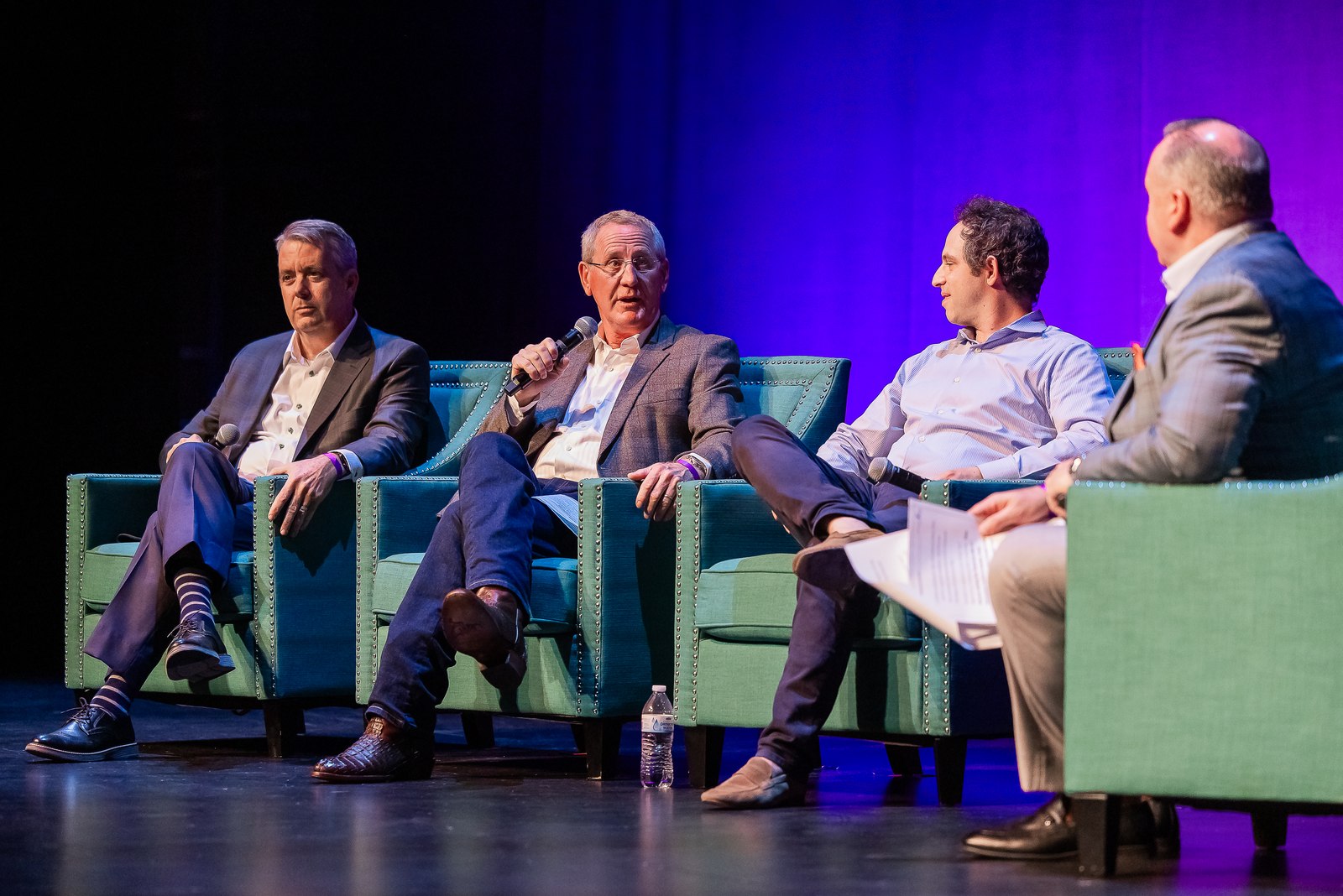 Panelists in conversation on a purple-lit stage at the A-LIST Awards.
