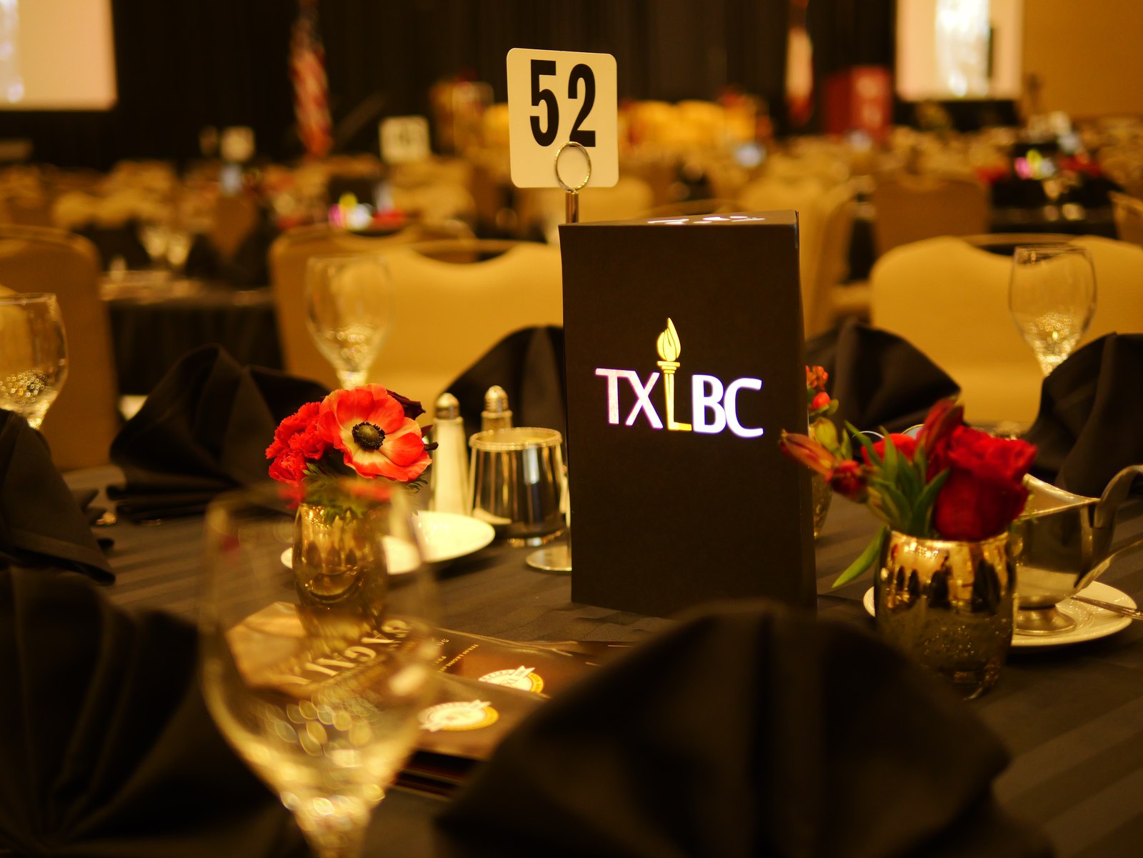 Gold table styling with red flowers at a Texas Legislative Black Caucus event.