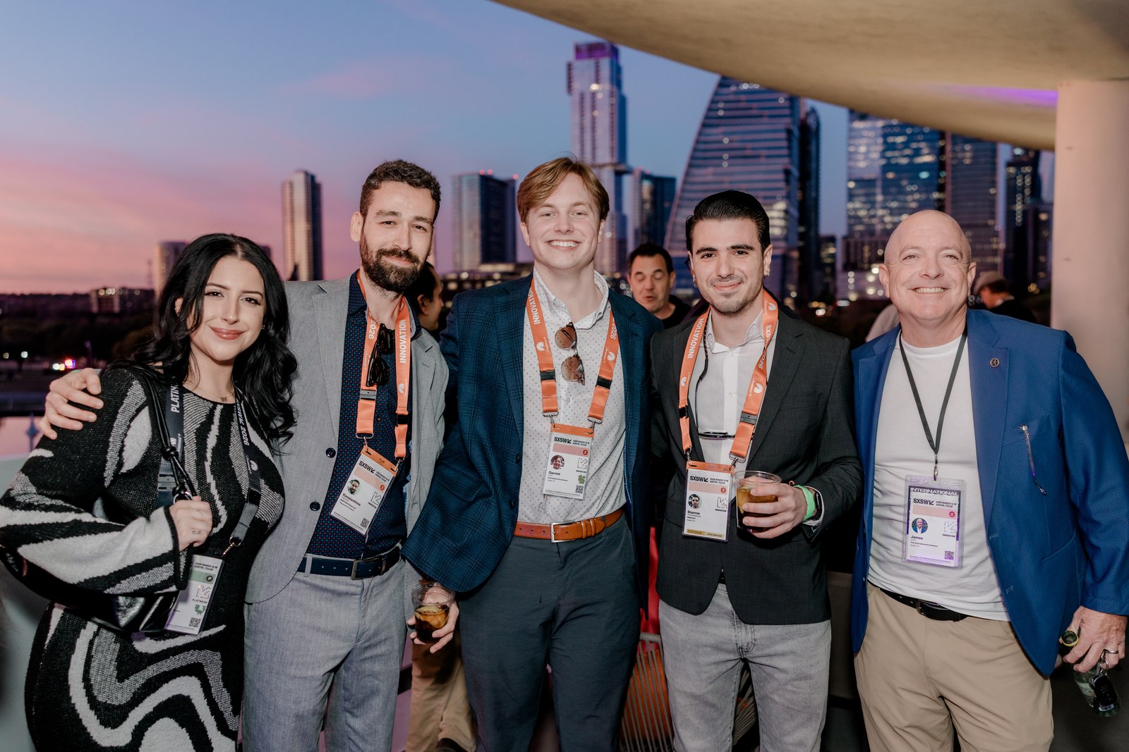 Guests together on a rooftop with the Austin skyline at dusk.